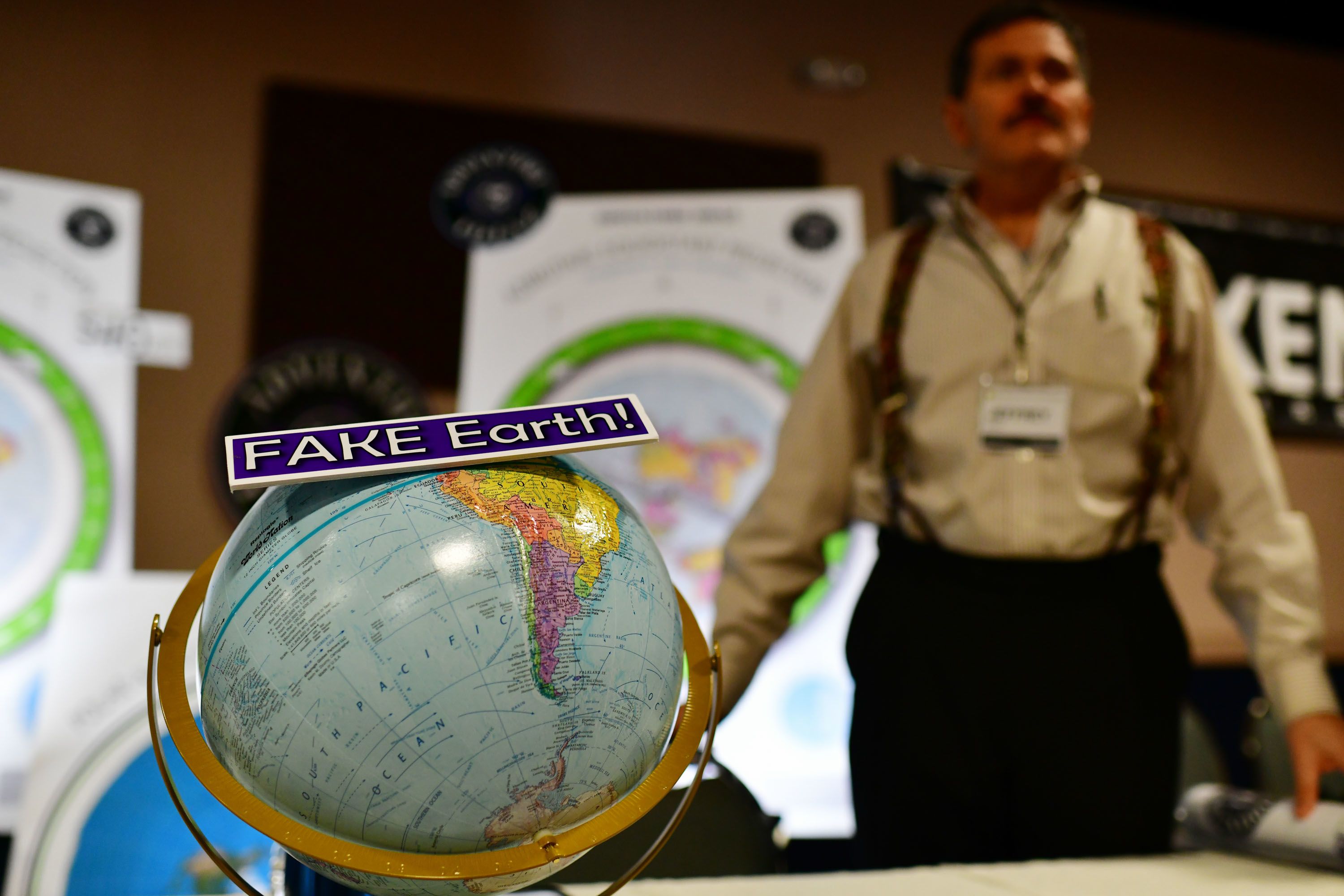 Globe with sign on it reading, "Fake Earth"