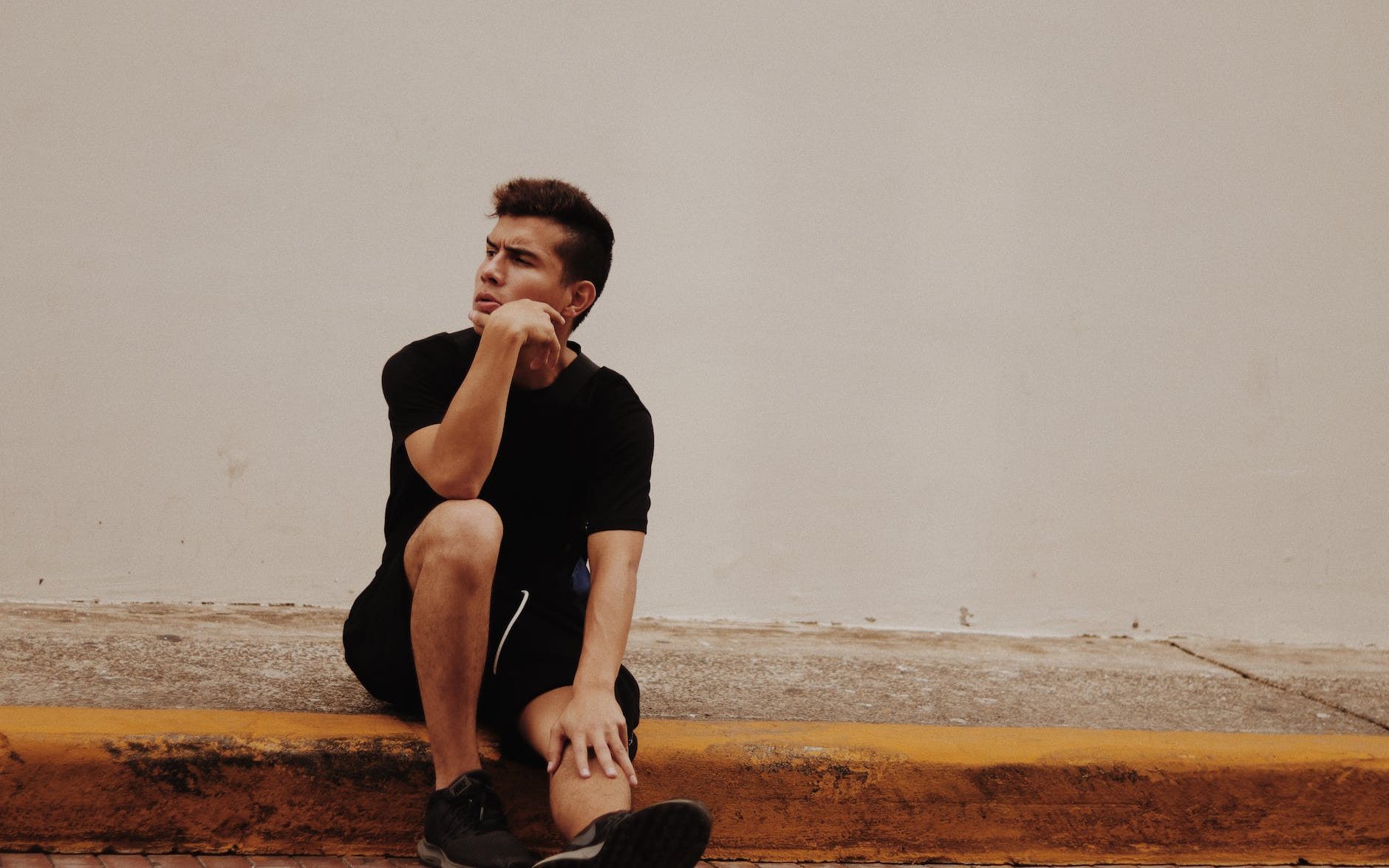 Man sitting on a curb thinking