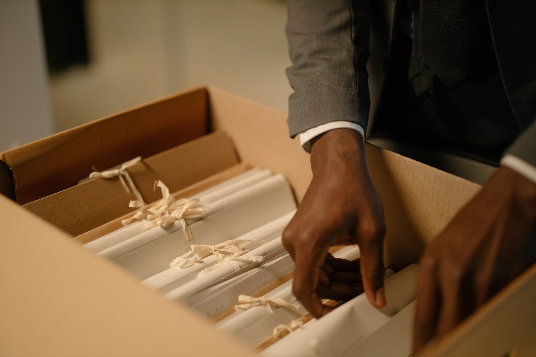 Close up of a man ruffling through folders in a box
